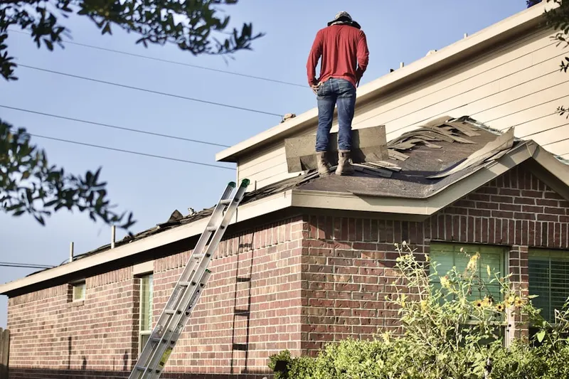 Professional roofer working on a residential roof in Benfield
